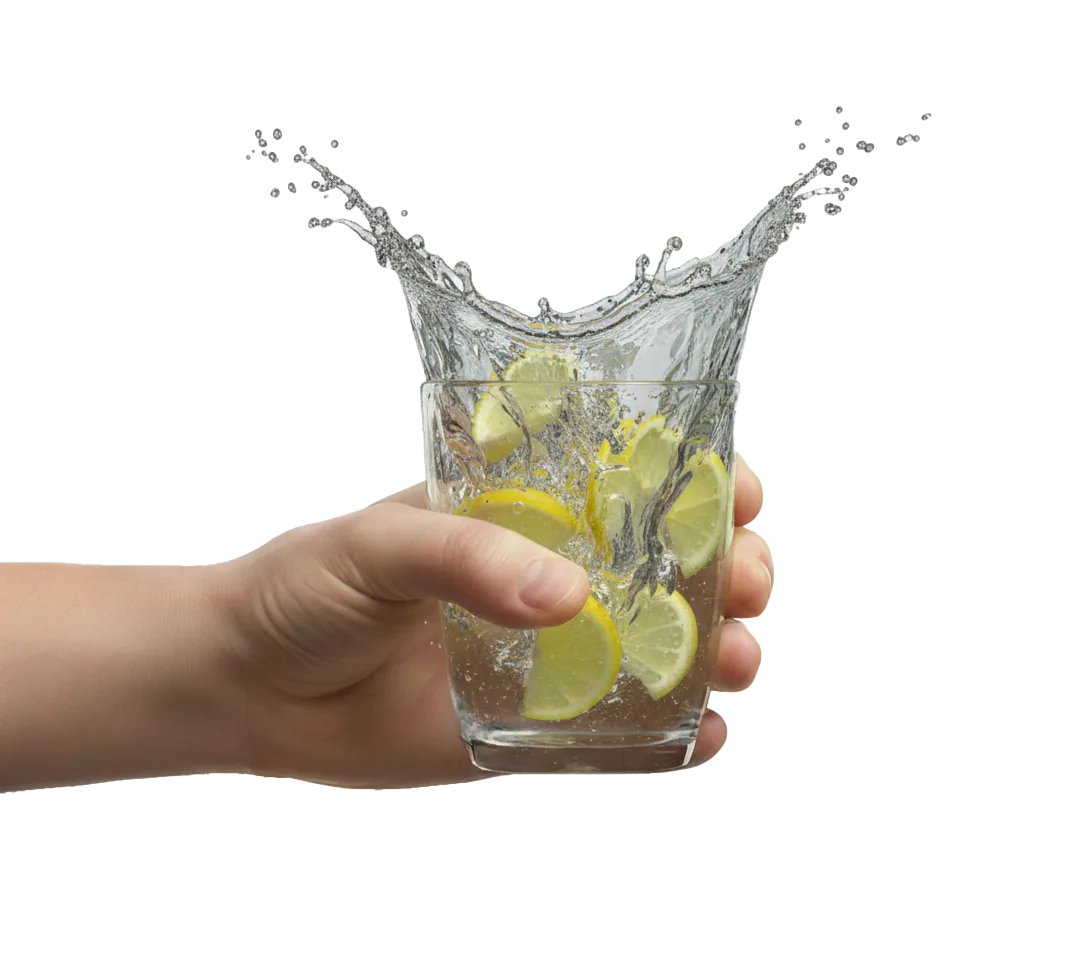 Hand holding a splashing glass of lemon water